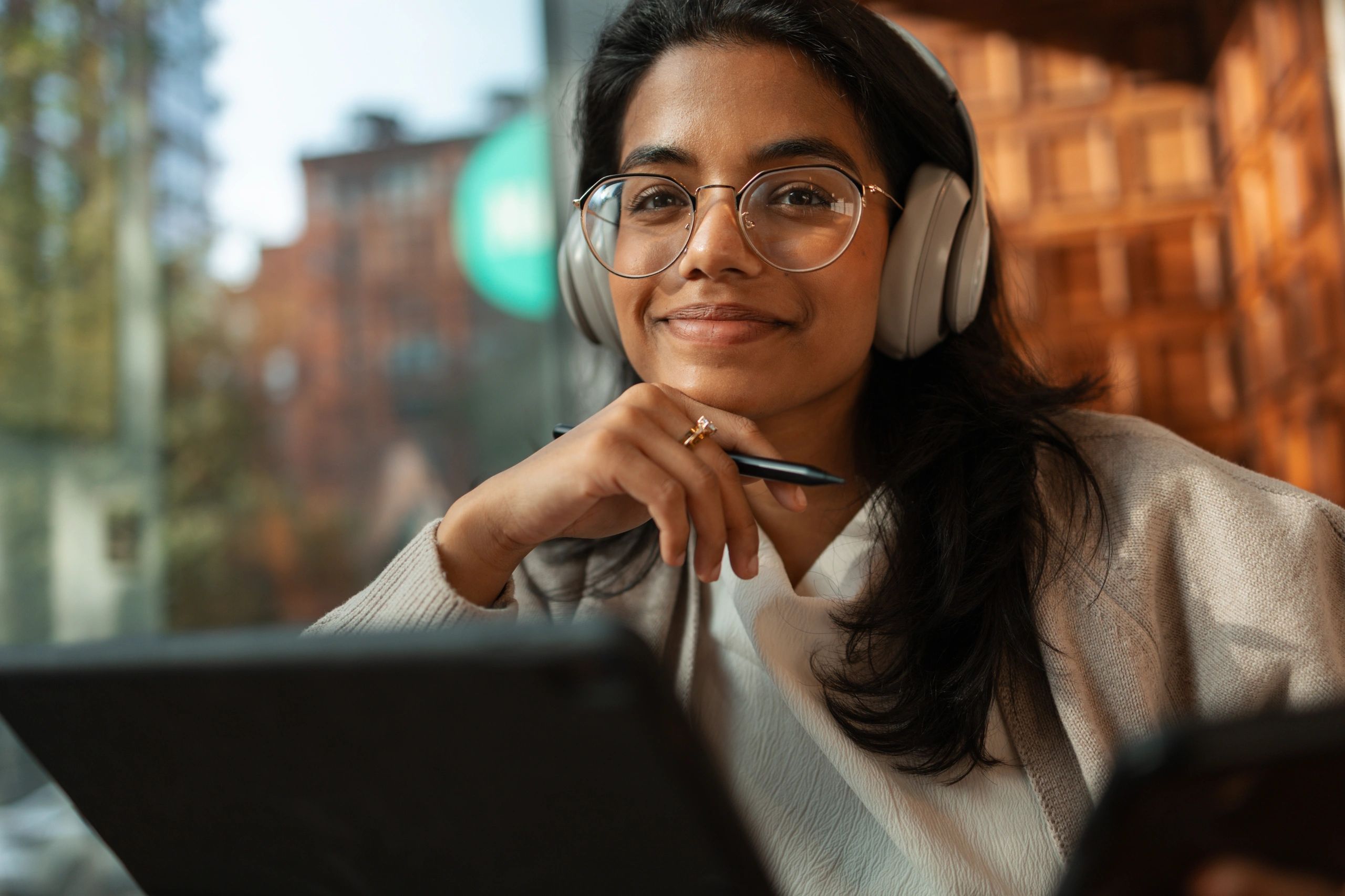 Woman studying with headphones in cafe