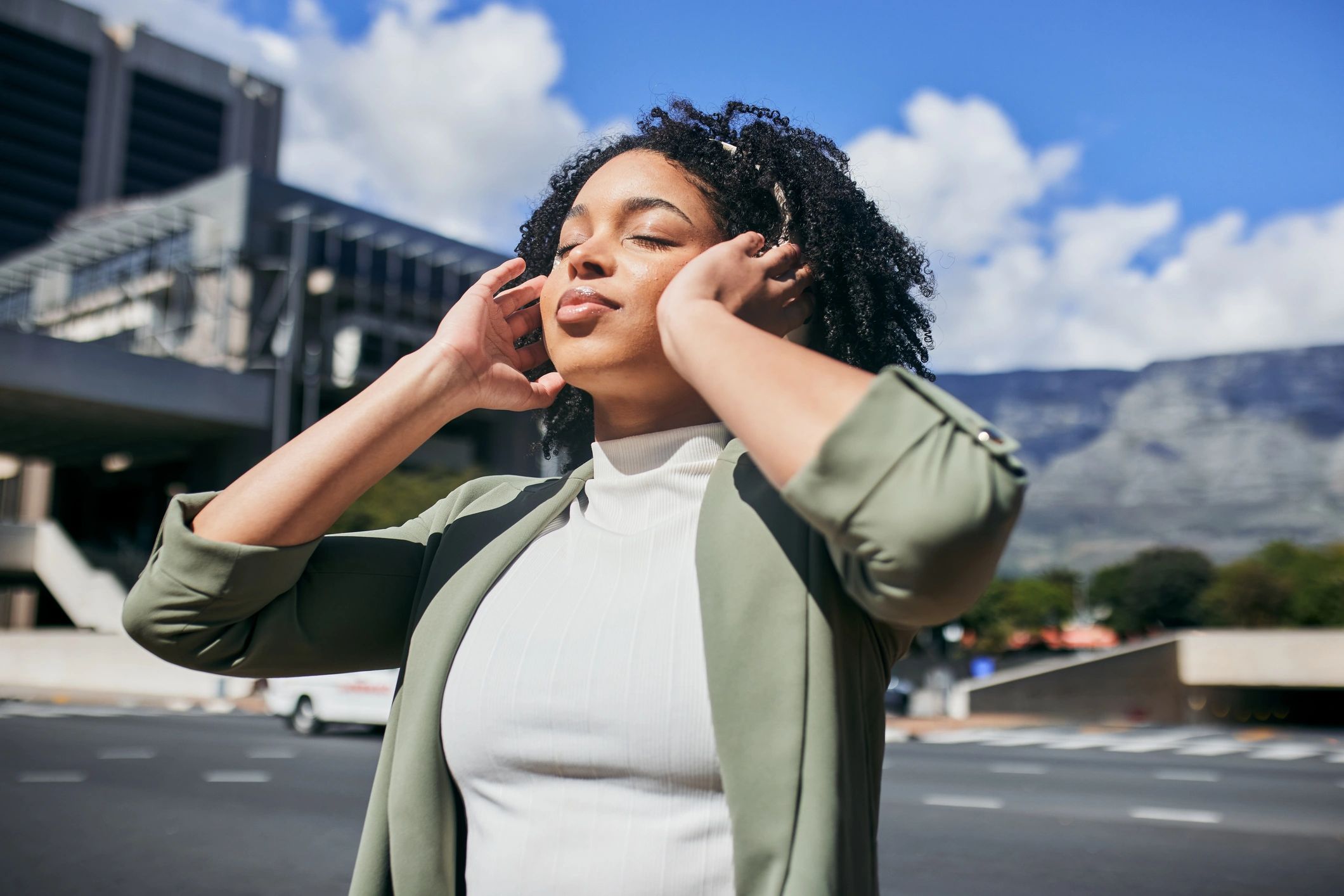 Person enjoying a peaceful moment listening to audio with headphones outdoors